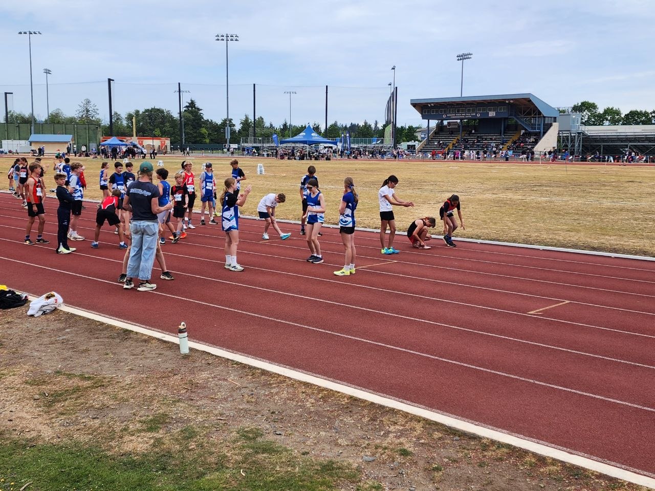 Club Rapide athletes warming up together at a track meet